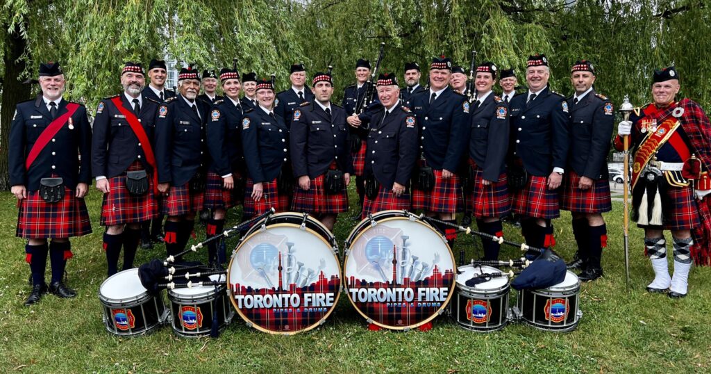Toronto Fire Pipes & Drums - Band in Tartan Uniform with drums and pipes on ground in front